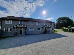 een groot grijs huis met een oprit ervoor bij Rom i bufellesskap in Sogndal