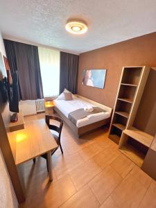 a hotel room with a bed and a book shelf at Hotel Frohnhauser Hof in Essen