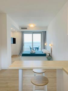 een slaapkamer met een bed, een tafel en een stoel bij Le Conchiglie Residence in Porto Torres