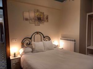 a bedroom with a large white bed with two lamps at Apartamento Ábside de San Juan III in Estella