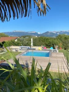 a swimming pool in a villa with mountains in the background at FalHappy House in Poisy