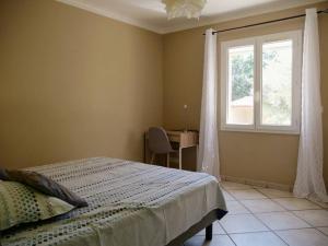 een slaapkamer met een bed, een raam en een bureau bij Belle villa individuelle climatisée piscine in Monteux