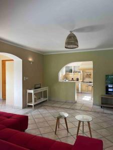 een woonkamer met een rode bank en een keuken bij Belle villa individuelle climatisée piscine in Monteux