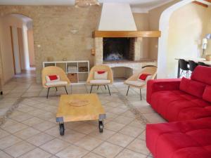 een woonkamer met een rode bank en stoelen bij Belle villa individuelle climatisée piscine in Monteux
