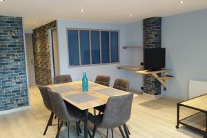 ein Esszimmer mit einem Holztisch und Stühlen in der Unterkunft Appartement tout équipé proche gare et centre in Dijon