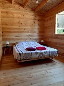 ein Schlafzimmer mit einem Bett in einem Blockhaus in der Unterkunft "Le Colibri" dans la colline in La Ciotat