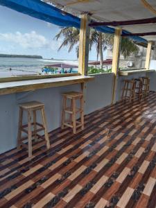 Lagudri的住宿－Friendly losmen，一个带两个凳子的酒吧,享有海景
