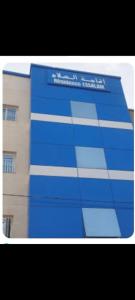 a blue building with a sign in front of it at RESIDANCE ESSALAM in Laayoune