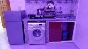 a kitchen with a washing machine under a counter at RESIDANCE ESSALAM in Laayoune