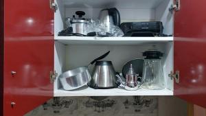 a kitchen cabinet filled with pots and pans at RESIDANCE ESSALAM in Laayoune