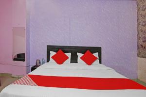 a bed with red pillows in a purple room at Super OYO Flagship Hotel Glorious Stayz in Noida