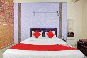 a bedroom with a large bed with red pillows at Super OYO Flagship Hotel Glorious Stayz in Noida