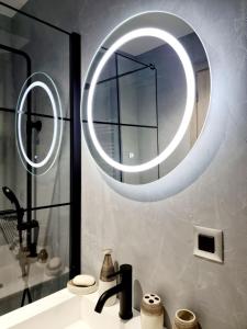 a bathroom with a sink and a large circular mirror at Castle luxury home in Chios +42 photos