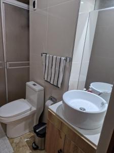 La salle de bains est pourvue d'un lavabo blanc et de toilettes. dans l'établissement Departamento con entrada independiente en Arequipa, à Santa Rosa