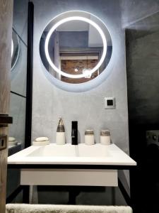 y baño con lavabo blanco y espejo circular. en Castle luxury home, en Chios
