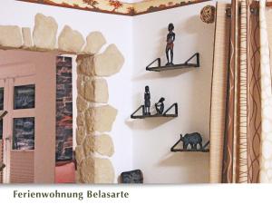 a wall with two shelves with figurines on them at Ferienwohnung Belasarte in Bad Elster