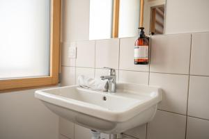 a white sink in a bathroom with a bottle of wine at UCPA SPORT STATION HOSTEL PARIS in Paris