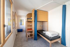 ein kleines Schlafzimmer mit einem Etagenbett und einer Leiter in der Unterkunft UCPA SPORT STATION HOSTEL PARIS in Paris