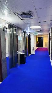 um corredor com um tapete azul num edifício em Royal Prince Hotel em Dubai