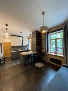 a kitchen and living room with a table and a window at Bougie Boutique Agenskalns in Rīga