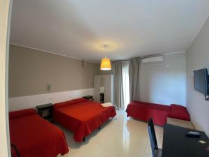 a living room with two beds and a red couch at Casantica B&B Turismo Rurale in Milazzo