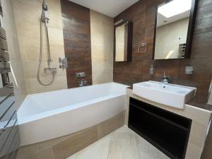a bathroom with a white tub and a sink at The Kilmainham Spire View Apartment in Dublin