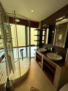 a bathroom with two sinks and a glass shower at The Kilmainham Spire View Apartment in Dublin