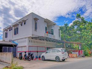 a white car parked in front of a building at OYO 92872 Swakarya Guest House in Parit