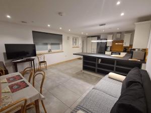a living room with a couch and a table and a kitchen at Modern two bedroom house in Ormiston