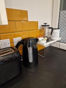 a black tea kettle is sitting next to a toaster at Modern two bedroom house 