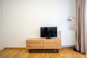 a tv sitting on top of a wooden cabinet in a room at Lefkas Town Apartment in Lefkada Town +31 photos