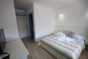 a bedroom with a bed with white towels on it at Pensiunea Ataman in Murighiol +40 photos