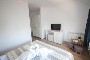 two white swans sitting on a bed in a bedroom at Pensiunea Ataman in Murighiol