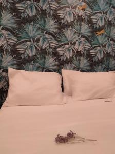 uma cama com duas almofadas e uma parede com plantas em Apartamentos Abadía. em Corella