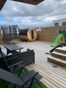 una terraza con parque infantil y juego de juegos en Luxury villa with gym and sauna, en Reikiavik