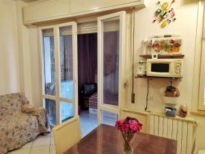 ein Wohnzimmer mit einem Tisch und einer Mikrowelle in der Unterkunft Appartamento Igea a 200 m dal mare in Bellaria-Igea Marina
