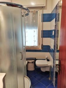 ein blau-weißes Bad mit einem WC und einer Dusche in der Unterkunft Appartamento Igea a 200 m dal mare in Bellaria-Igea Marina