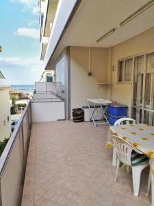 eine Terrasse mit einem Tisch und Stühlen auf dem Balkon in der Unterkunft Appartamento Igea a 200 m dal mare in Bellaria-Igea Marina