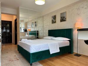 een slaapkamer met een groot groen bed met witte lakens bij Studios Copou IRO Parhon in Iaşi