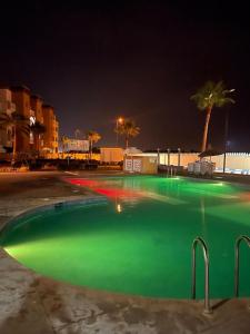 une piscine vide avec éclairage vert la nuit dans l'établissement Appartement résidence Al Kawtar, à Mohammedia