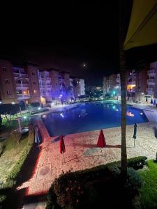 - une grande piscine en ville la nuit dans l'établissement Appartement résidence Al Kawtar, à Mohammedia