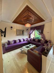 - un salon avec un canapé violet et une table dans l'établissement Appartement résidence Al Kawtar, à Mohammedia