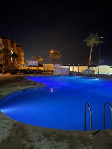 - une grande piscine bleue la nuit dans l'établissement Appartement résidence Al Kawtar, à Mohammedia