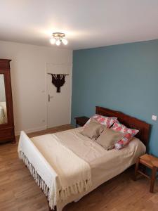 - une chambre dotée d'un lit avec un mur bleu dans l'établissement villa bruyeres, à Thiers