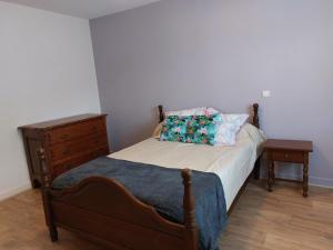 a bed with two pillows and a dresser in a bedroom at villa bruyeres in Thiers