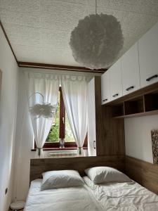 1 dormitorio con cama y ventana en Apartments & wellness Kal Koritnica, en Bovec