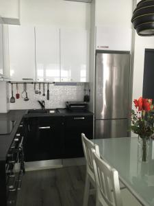 a kitchen with a table and a stainless steel refrigerator at Poukamankatu 14 As, 1 in Kuopio