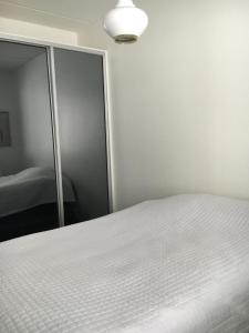 a bedroom with a white bed and a mirror at Poukamankatu 14 As, 1 in Kuopio