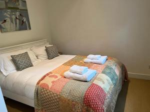 a bedroom with a bed with two towels on it at The Figgy by Bloom Stays in Ashford