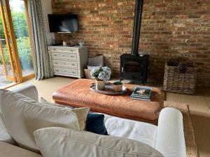 a living room with a table and a fireplace at The Figgy by Bloom Stays in Ashford